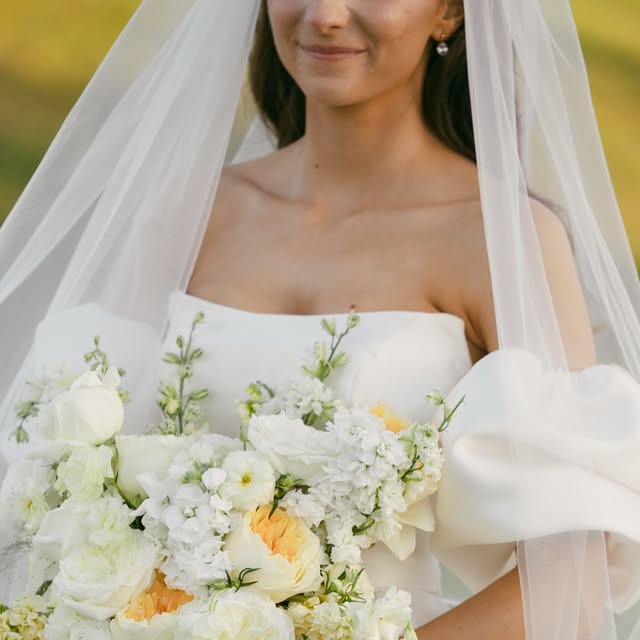 Bride holding a white and butter-yellow garden bouquet