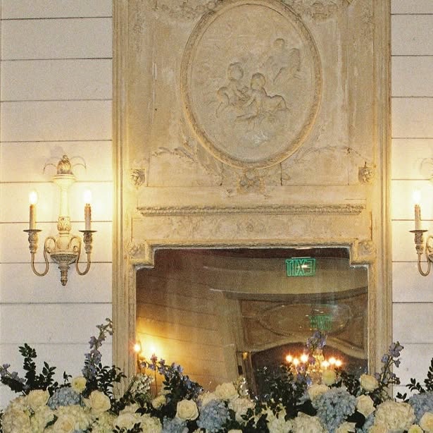 Candlelit mantel dressed with blue and white florals at a winter wedding